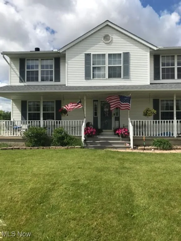 Traditional-style home with a porch and a front lawn