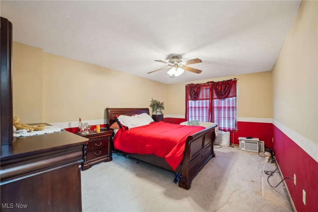 Bedroom featuring ceiling fan and carpet