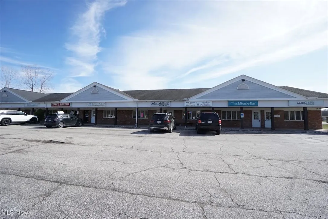 View of building exterior featuring uncovered parking