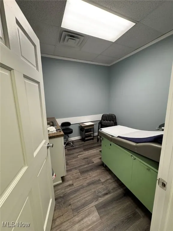 Office / exam room with visible vents, a paneled ceiling, and dark wood-style flooring