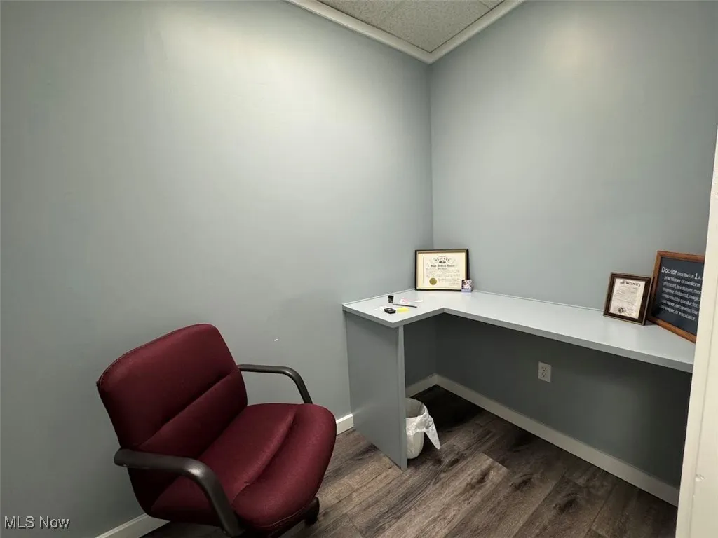 Office featuring baseboards, dark wood-type flooring, and a drop ceiling