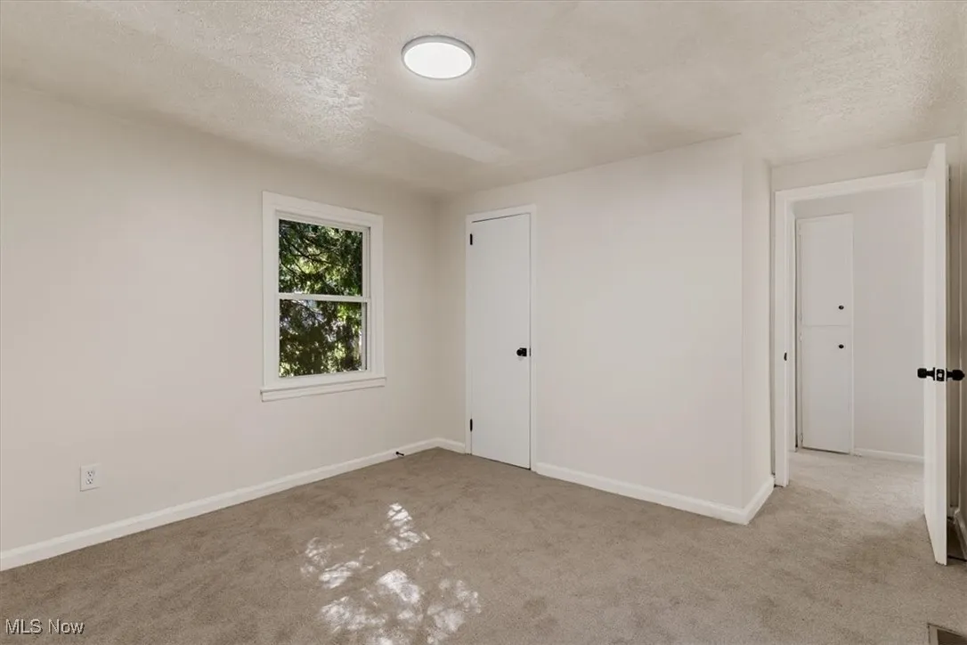 Unfurnished bedroom featuring a textured ceiling and carpet flooring