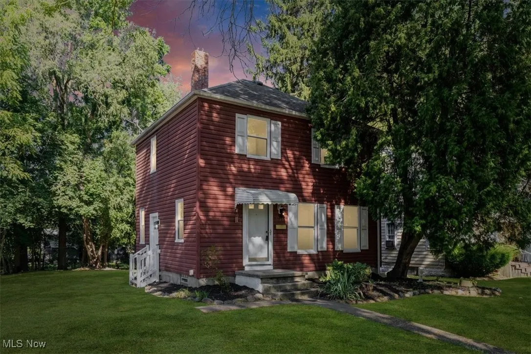 View of front facade featuring a lawn and a chimney