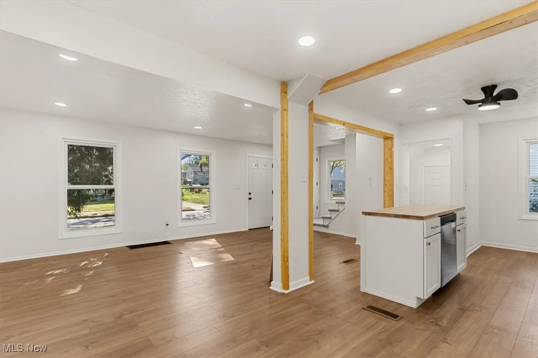 Kitchen with wood counters, white cabinets, open floor plan, light wood-style floors, and recessed lighting