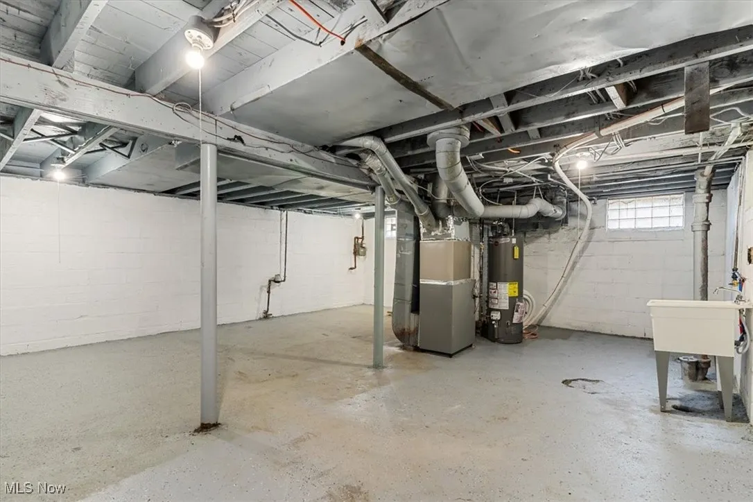 Below grade area featuring water heater and heating unit