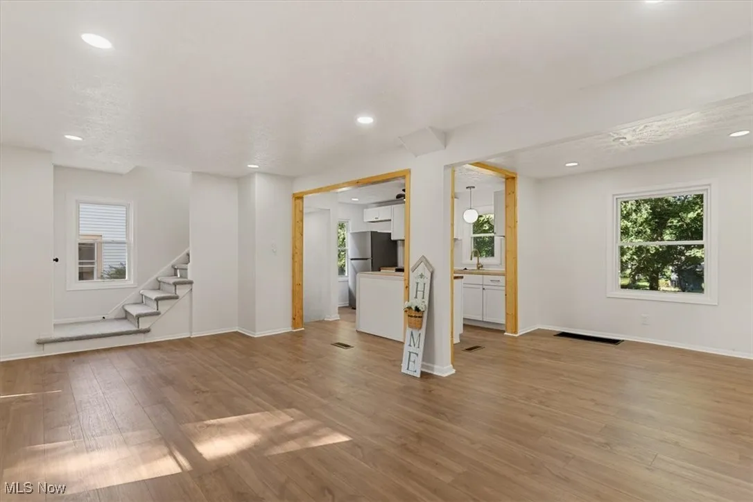 Unfurnished living room with recessed lighting, light wood-style floors, and stairway