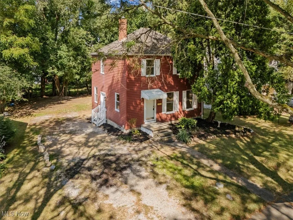 Colonial home featuring a chimney and driveway