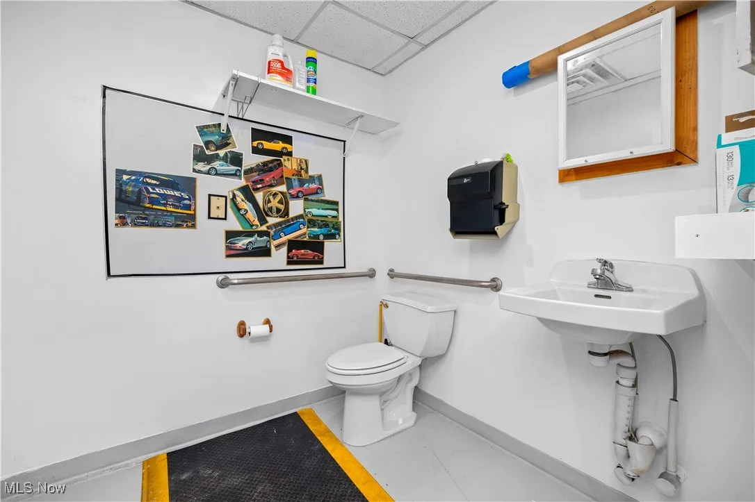 Half bathroom with a paneled ceiling and tile patterned floors