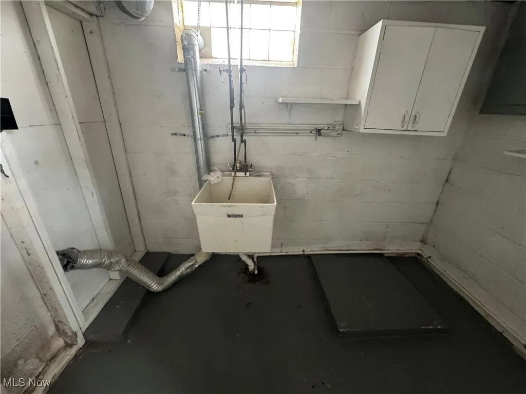 Basement with a sink and concrete block wall