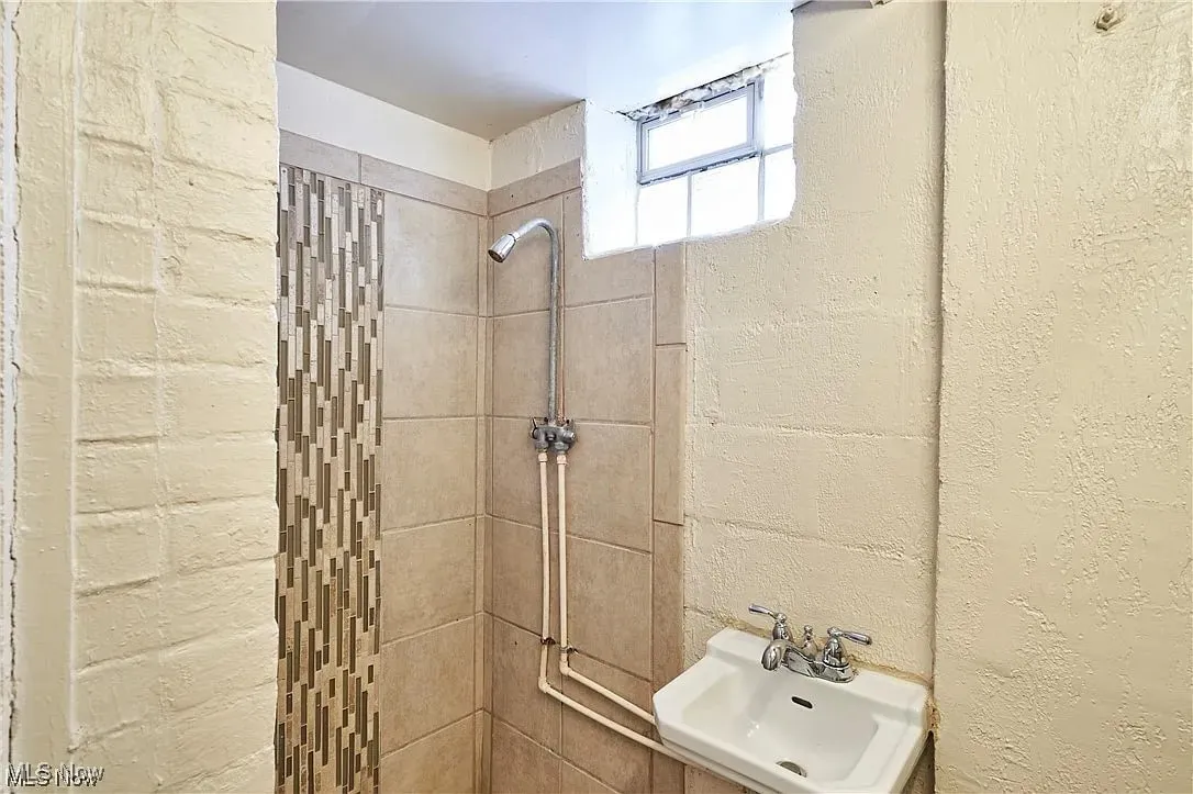 Bathroom with tiled shower and a sink