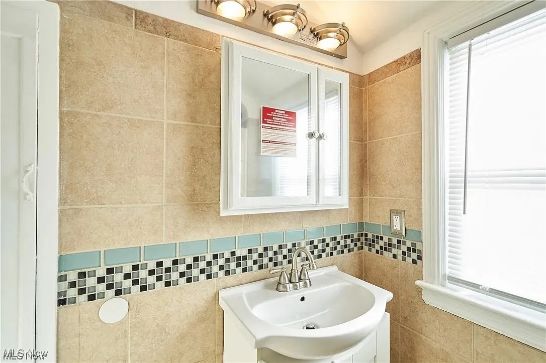 Bathroom with tile walls and a sink