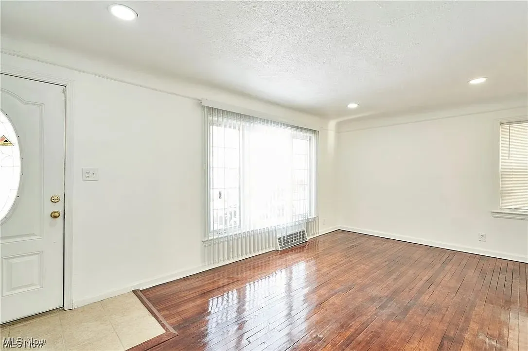 Foyer with hardwood / wood-style floors, a textured ceiling, baseboards, and recessed lighting