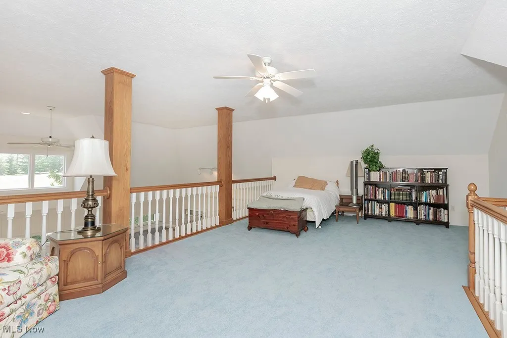 Carpeted loft featuring lofted ceiling and a textured ceiling