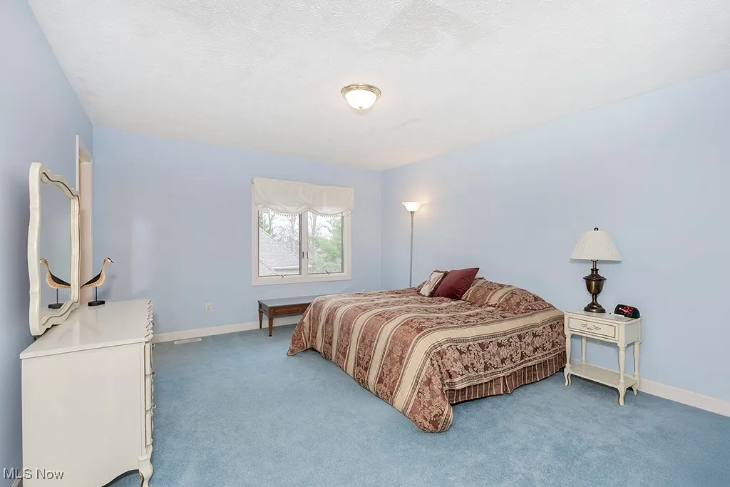 Bedroom featuring baseboards, carpet, and a textured ceiling