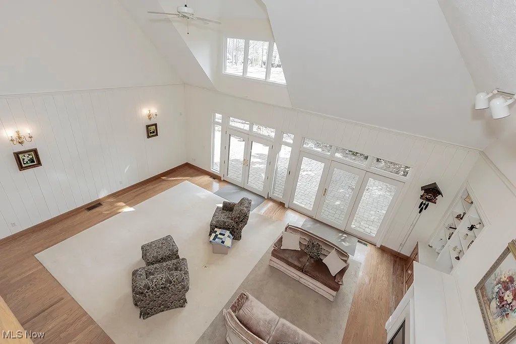 Living room with visible vents, high vaulted ceiling, wood finished floors, and a ceiling fan