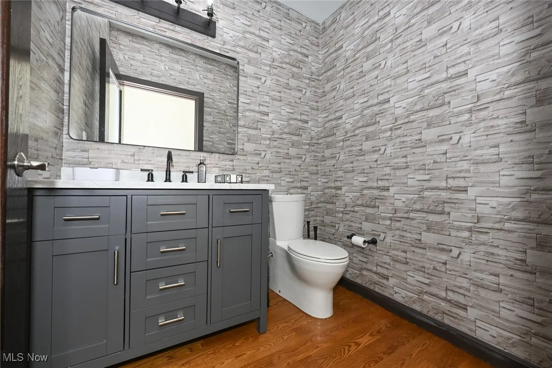 Bathroom with wood finished floors, toilet, and vanity