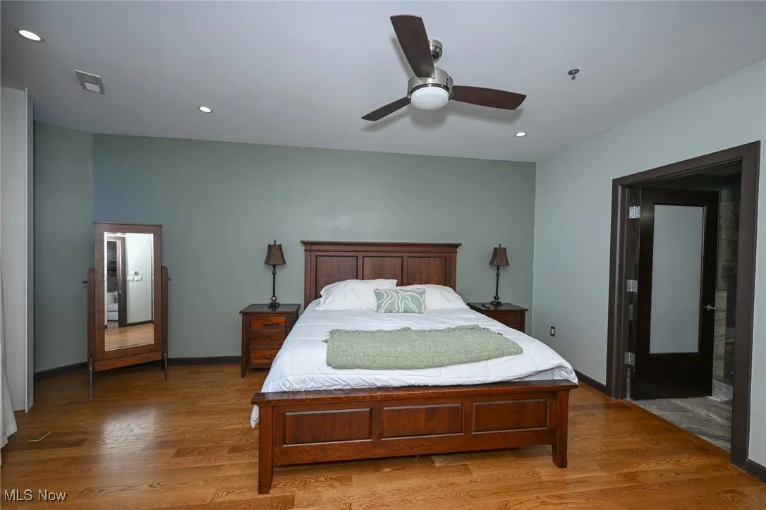 Bedroom with baseboards, visible vents, light wood-style flooring, and recessed lighting