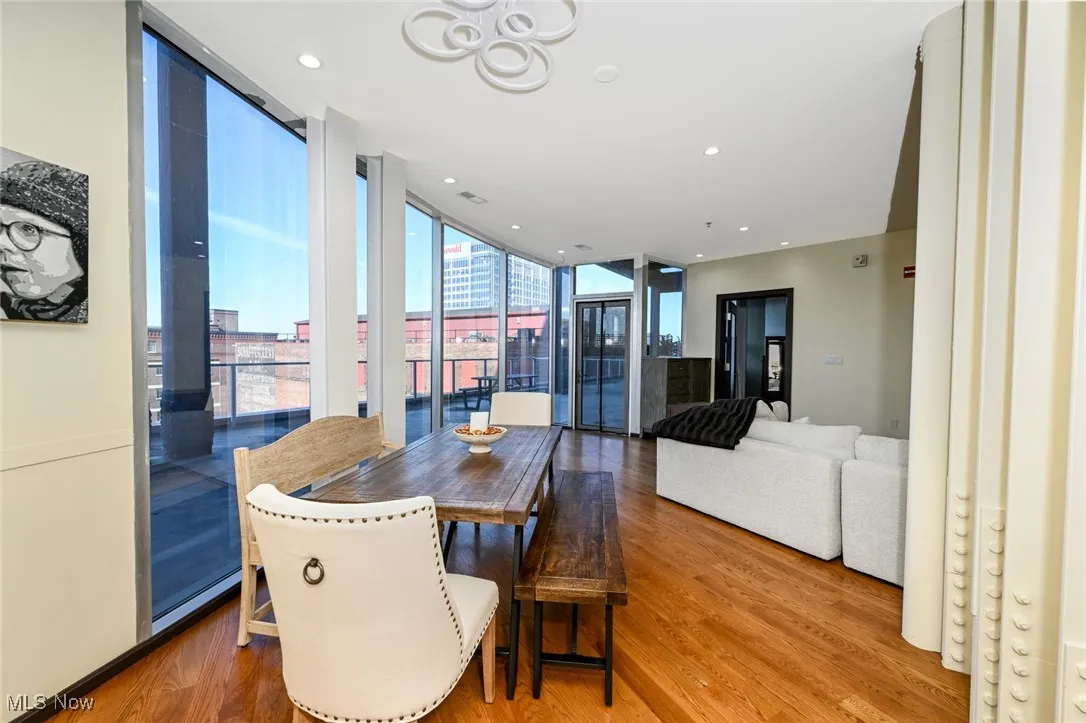 Dining room featuring floor to ceiling windows, recessed lighting, visible vents, and wood finished floors