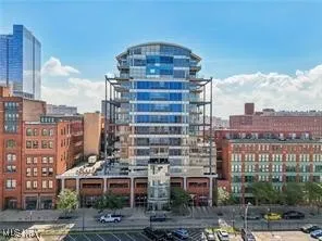 View of building exterior featuring uncovered parking and a city view