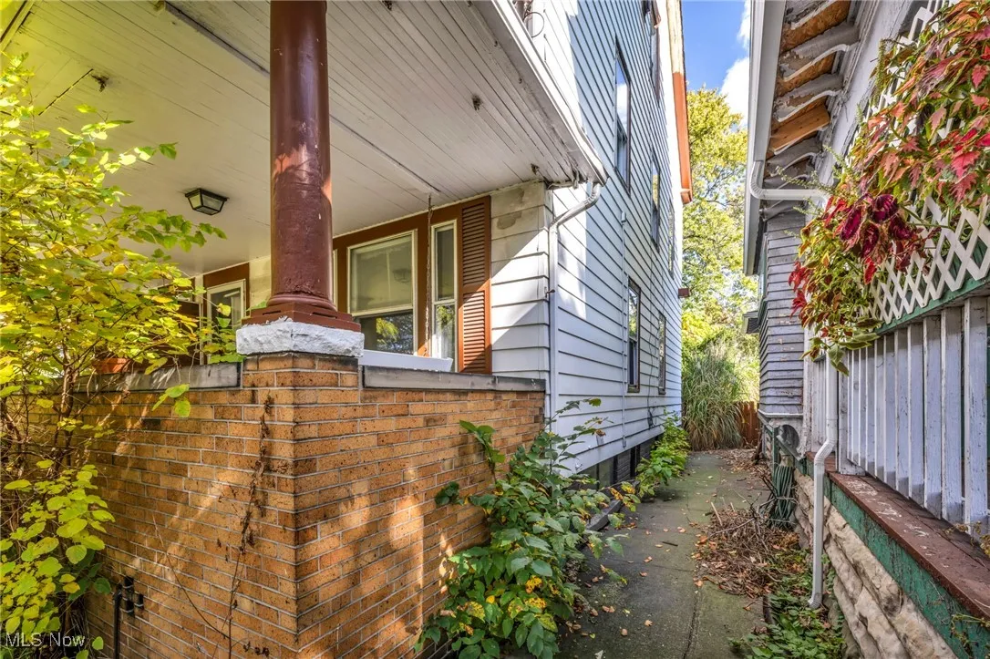 View of home's exterior featuring a porch and fence