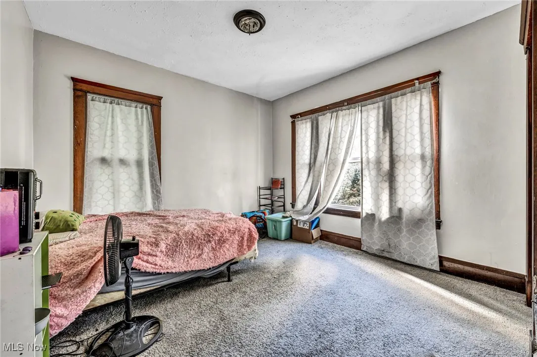 Carpeted bedroom with baseboards and a textured ceiling