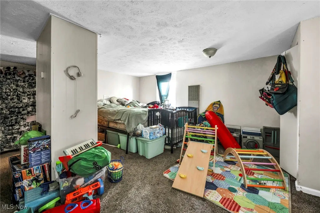 Carpeted bedroom featuring a textured ceiling