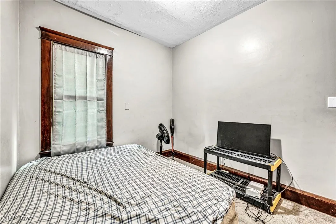 Bedroom featuring baseboards and a textured ceiling