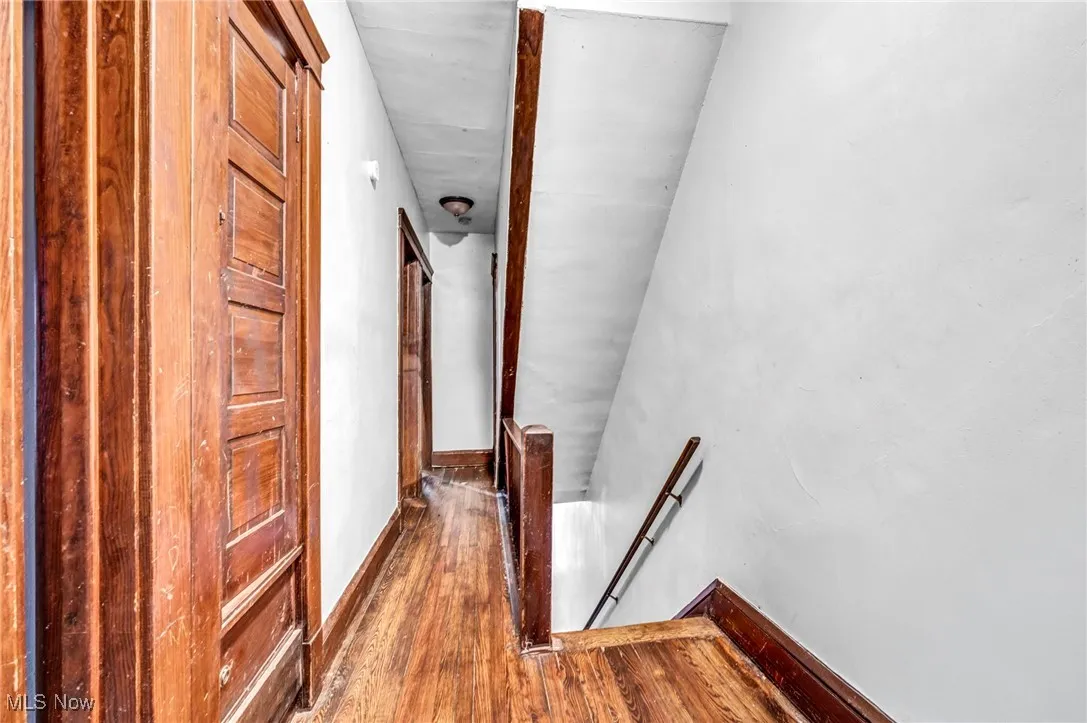 Hallway with baseboards, an upstairs landing, and hardwood / wood-style floors