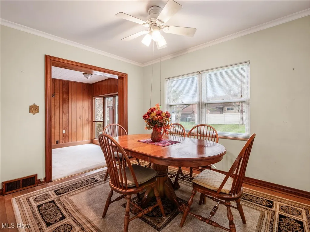 Dining room featuring baseboards, visible vents, crown molding, and ceiling fan