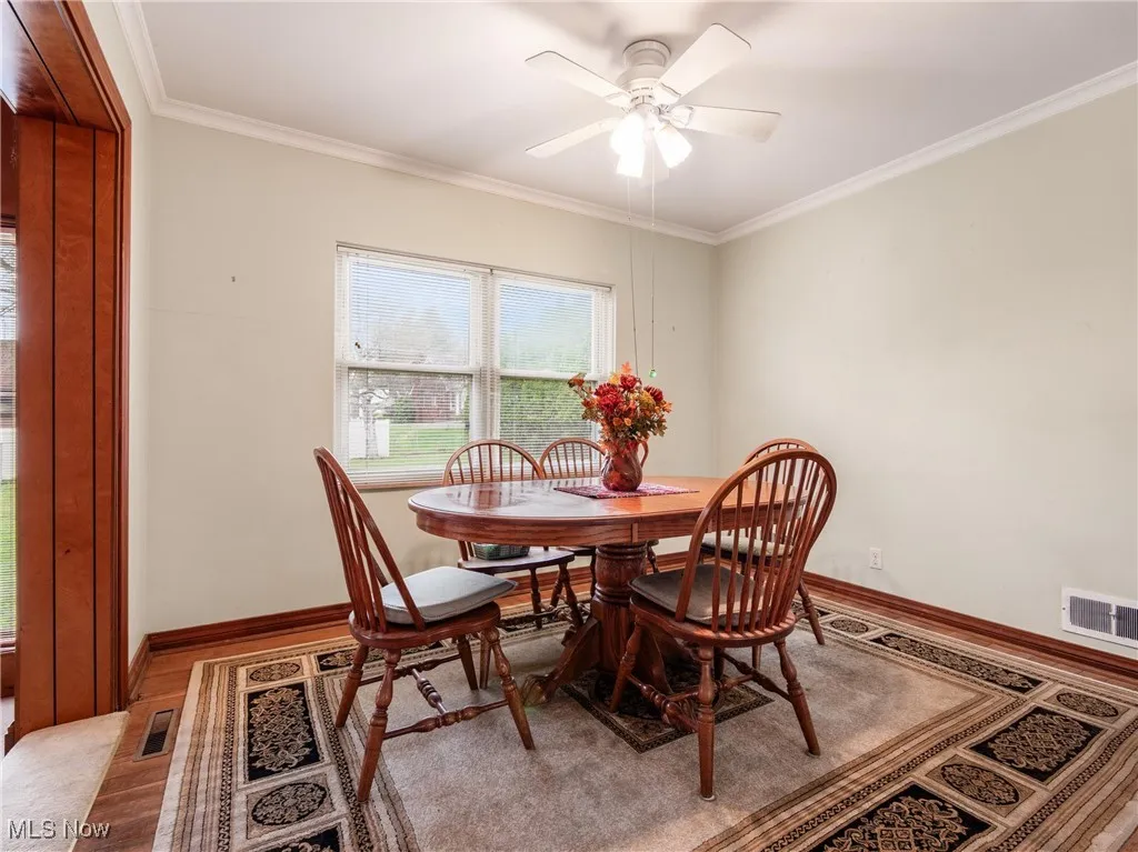 Dining room featuring baseboards, visible vents, and crown molding