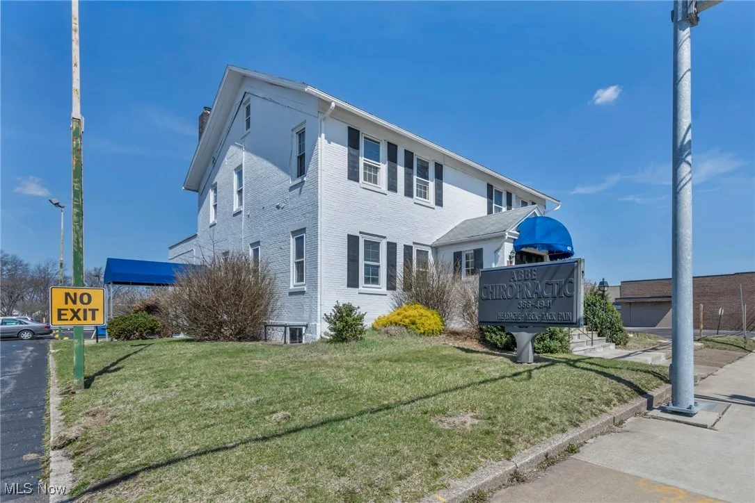 View of property exterior featuring a lawn and brick siding