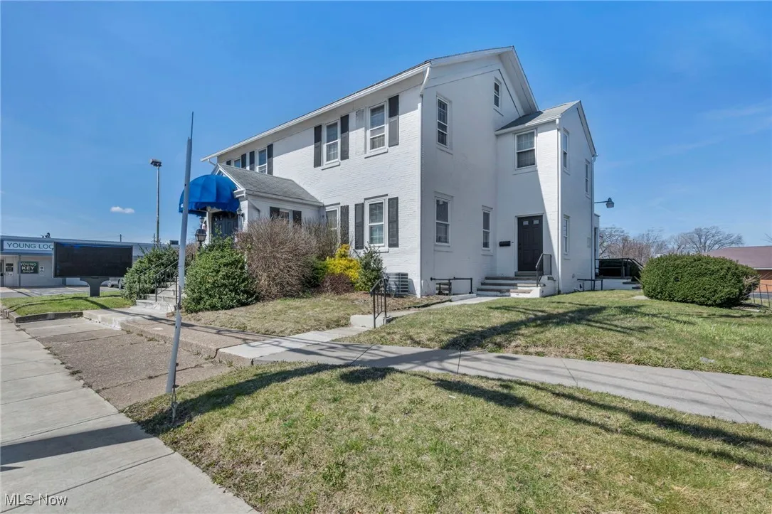 View of front facade featuring a front yard and stucco siding