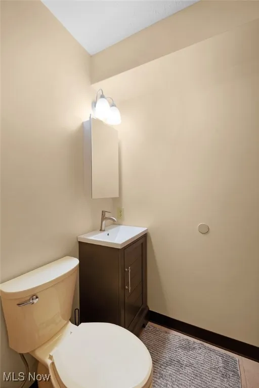 Bathroom featuring baseboards, toilet, and vanity