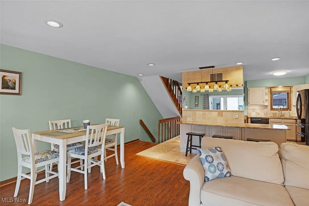 Dining room with stairs, wood finished floors, baseboards, visible vents, and recessed lighting
