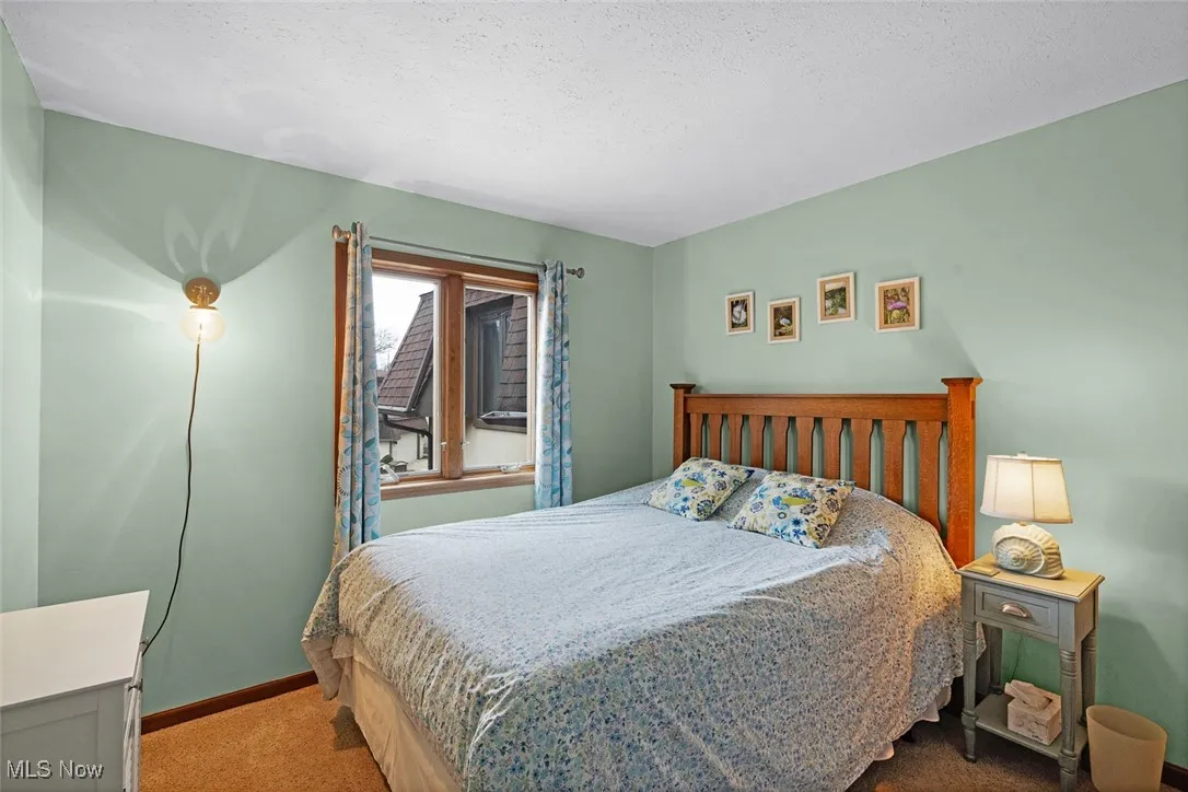 Carpeted bedroom with baseboards and a textured ceiling