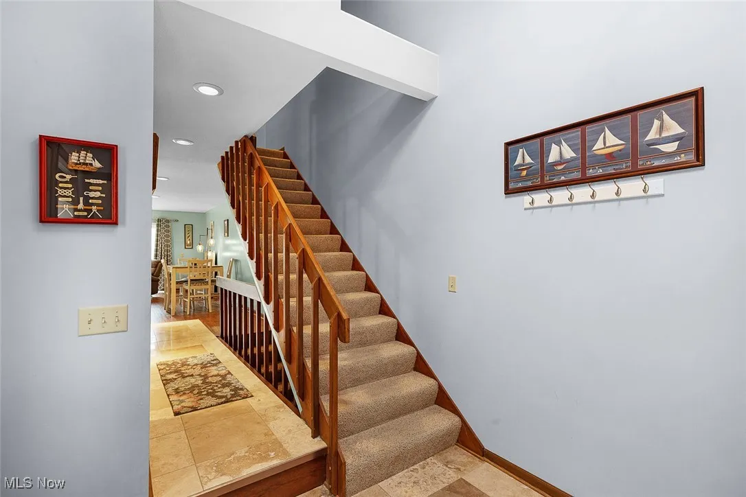 Staircase with baseboards and recessed lighting