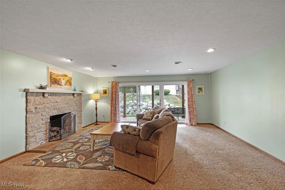 Living area with baseboards, a fireplace, and carpet floors