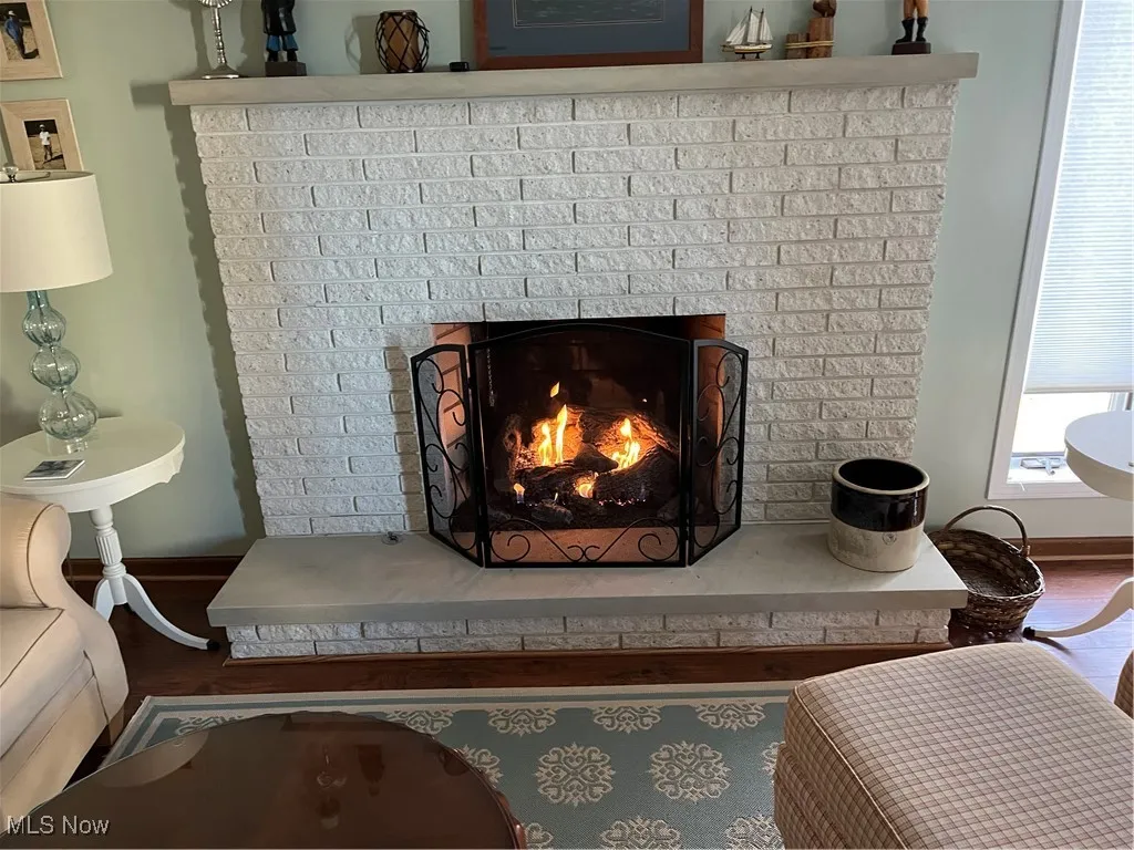 Details with a brick fireplace, baseboards, and wood finished floors