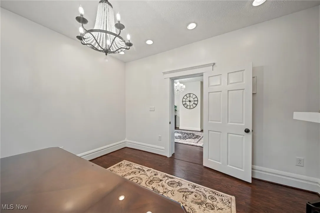 Foyer featuring baseboards, wood finished floors, recessed lighting, and a notable chandelier