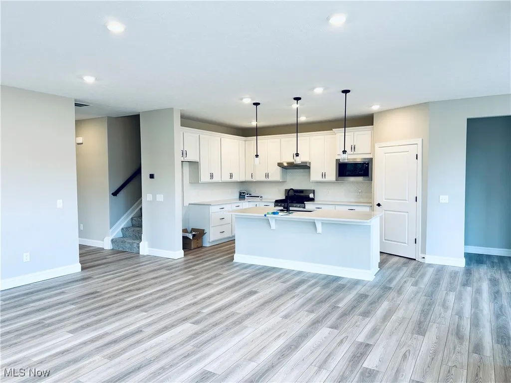 White maple cabinetry and quartz countertops in the kitchen