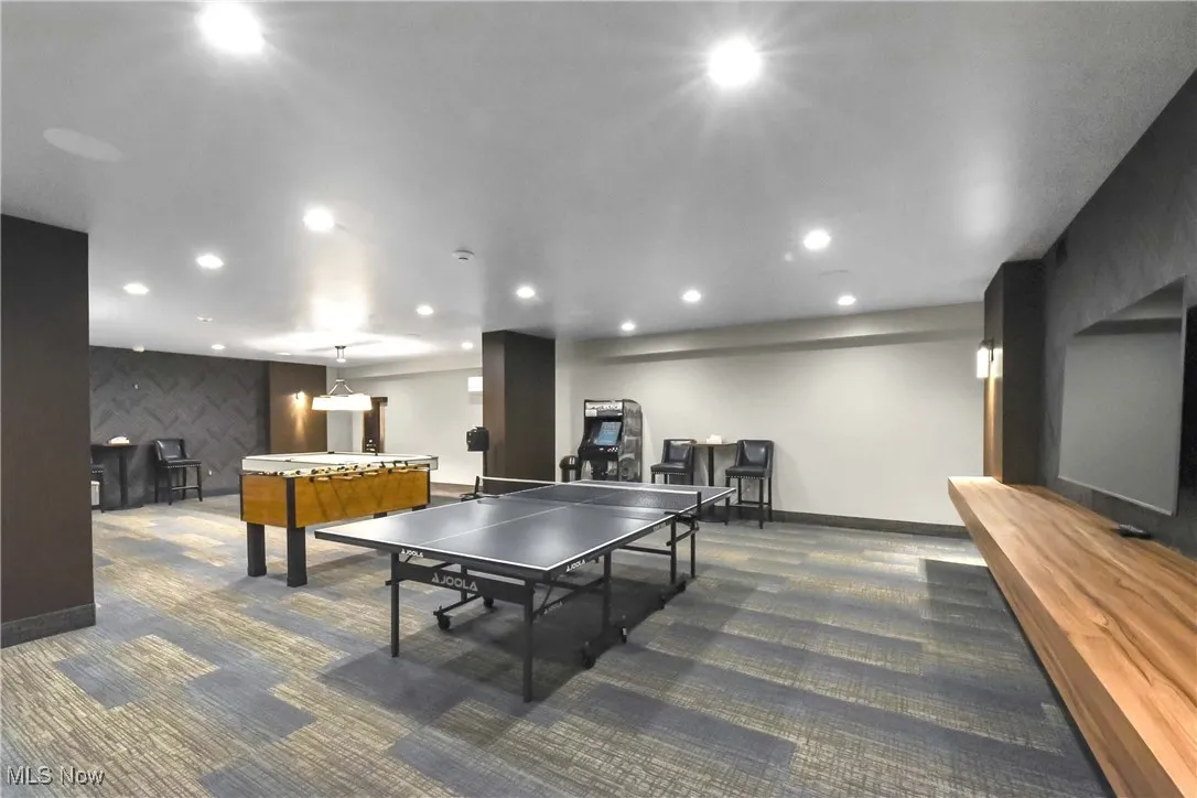 Rec room featuring carpet flooring, baseboards, an accent wall, and recessed lighting