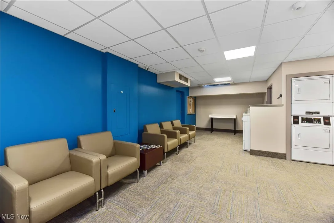Community lobby featuring stacked washing maching and dryer and visible vents