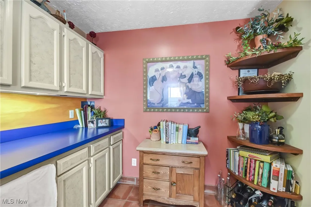 Kitchen with a textured ceiling and tile patterned flooring