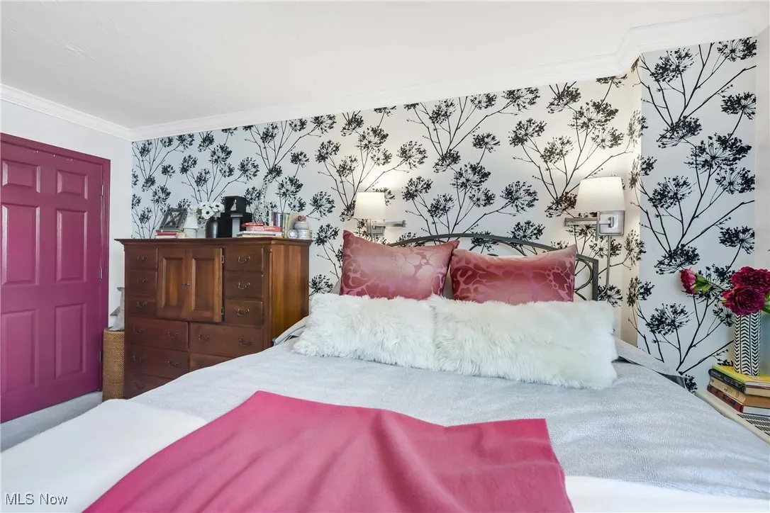 Bedroom with wallpapered walls and ornamental molding