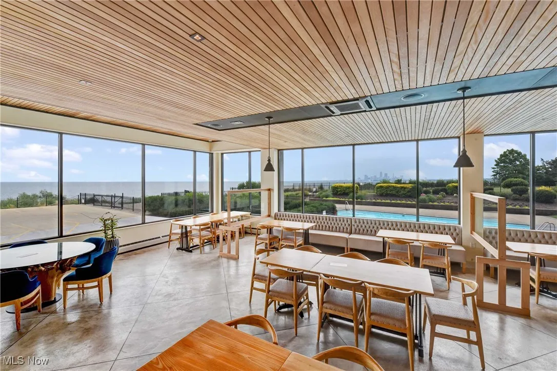 Sunroom / solarium with wood ceiling, plenty of natural light, and finished concrete floors