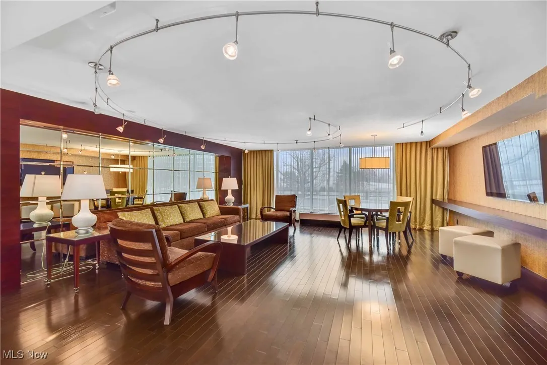 Living room with hardwood / wood-style floors and track lighting