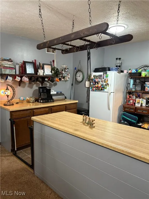 Kitchen with a textured ceiling, light countertops
