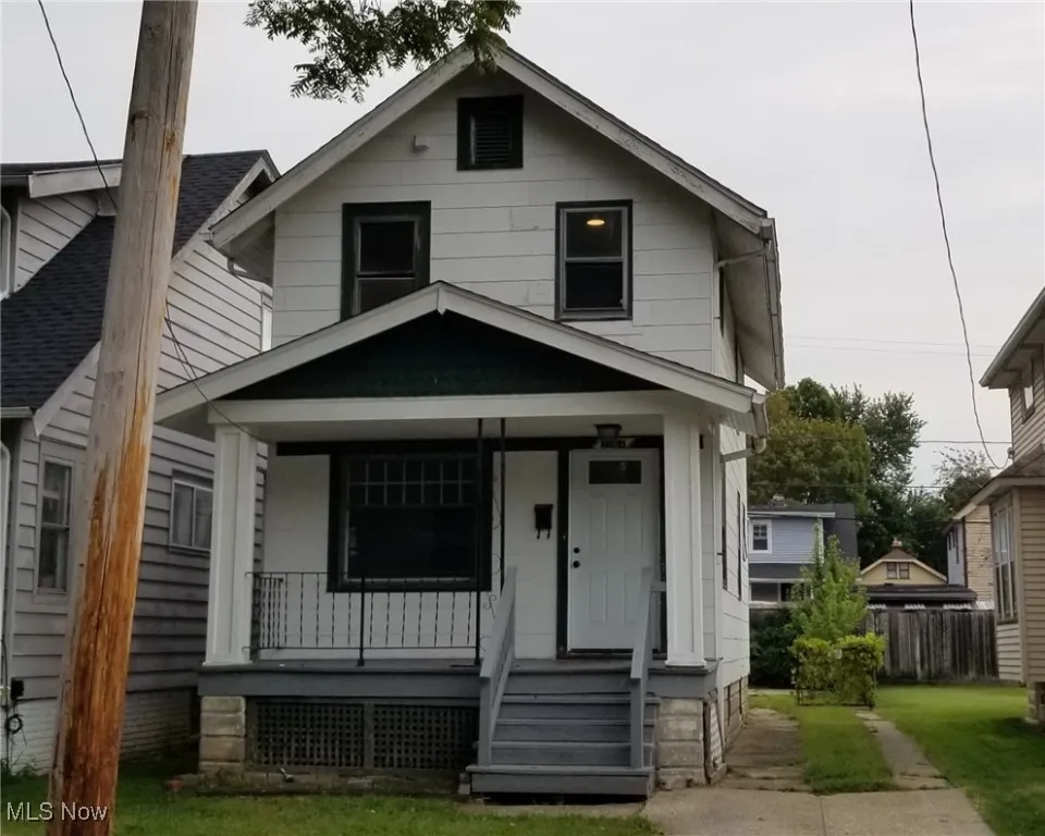 View of front of home with a porch and fence