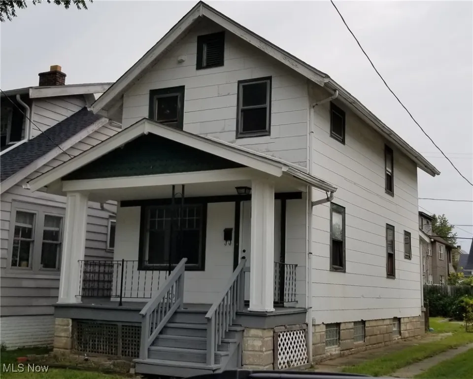 View of front facade with covered porch and a chimney