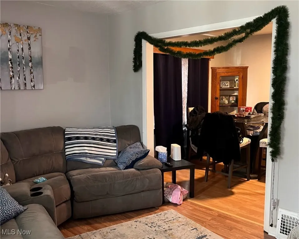 Living room with visible vents and light wood finished floors